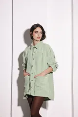 Sobrecamisa verde agua de pana con cuello camisero, cierre frontal con botones y bolsillos de parche.