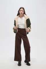 Campera puffer de poliamida color verde militar, con interior y detalles en corderito color crema. Presenta cuello alto, cierre frontal con botones a presión y mangas largas.