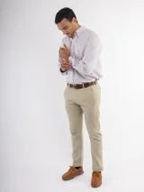 Camisa de corte clásico confeccionada en algodón, con diseño de rayas verticales en tonos claros, cuello abotonado y manga larga. Presenta un pequeño bordado en el pecho.