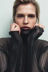 Top semitransparente de punto fino color negro, con cuello subido y manga larga.