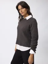 Sweater de tejido acanalado con cuello redondo y manga larga. Presenta un corte relajado y textura estructurada.