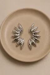 Aros tipo ear cuff de diseño moderno, compuestos por múltiples piezas metálicas con forma de pétalo o gota en acabado plateado brillante, dispuestos en abanico.