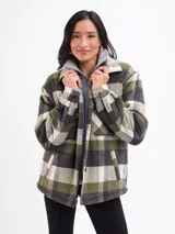Sobrecamisa de corte holgado con estampado de cuadros en tonos azul, blanco y marrón. Presenta cierre frontal con botones, cuello clásico, bolsillos en el pecho y un interior forrado en sherpa color beige.