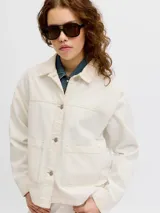 Chaqueta de denim en color crudo, con cierre frontal de botones metálicos, bolsillos frontales aplicados y cuello camisero.