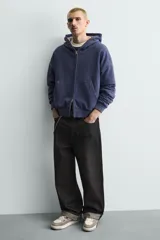 Zapatilla deportiva de cordones, con parte superior en combinación de piezas y materiales en tonos blanco, gris claro y gris oscuro. Suela con volumen.