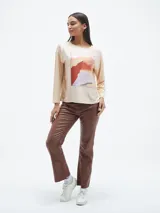 Blusa de manga larga color azul, con cuello redondo y estampa frontal geométrica con detalles de lentejuelas y texto.