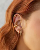Set de aros dorados con diferentes diseños: un aro liso, un aro con textura, un aro con tres hileras de strass y un cuff liso.
