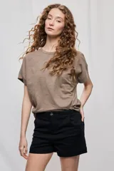 Remera negra de manga corta con cuello redondo y silueta amplia, de hombros caídos y textura suave.