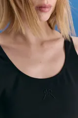 Top deportivo de escote en U, confeccionado en lycra con textura tipo neoprene. Presenta un isologo bordado en el frente y un diseño ajustado al cuerpo.