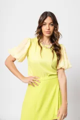 Blusa verde con cuello redondo y mangas cortas abullonadas.