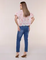 Camisa de gasa rosa con estampado floral y bordados, cuello camisero, mangas cortas abullonadas y cierre frontal de botones.