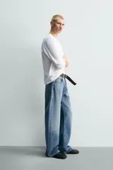 Camiseta de manga larga color gris jaspeado, corte regular fit y cuello redondo con acabado en rib.