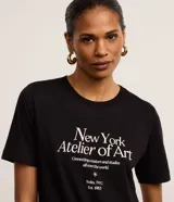 Remera slim de algodón negro, con cuello redondo, mangas cortas y estampa frontal "New York Atelier of Art" en color blanco.
