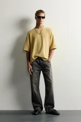 Jeans flare fit de denim de algodón en color gris con efecto lavado. Presentan diseño de cinco bolsillos, tiro medio y cierre frontal con cremallera y botón.