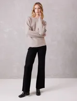 Buzo de punto acanalado horizontal con textura suave. Presenta un calce holgado, escote a la base y diseño de manga japonesa con caída fluida.