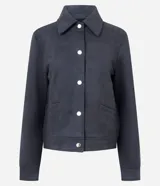 Chaqueta de corte recto confeccionada en suede sintético color marrón. Presenta cuello estilo camisa, cierre frontal con botones metálicos, mangas largas con puños ajustados y bolsillos embutidos.