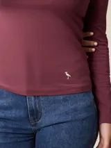 Remera de manga larga con cuello tortuga, confeccionada en tejido de algodón con elastano, de corte ajustado al cuerpo y diseño liso.