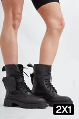 Borcegos de cuero negro con cordones, suela track de goma y bolsillo lateral extraíble con cierre.