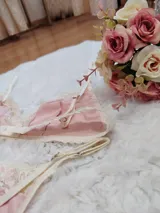 Conjunto de lencería compuesto por un corpiño triangular y una bombacha tipo tanga, confeccionados en algodón color salmón con detalles de puntilla en tono champagne.