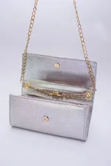 Cartera tipo sobre color beige con textura granulada y correa de cadena dorada.