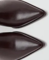 Botines de caña corta color bordó, con efecto de cuero, punta fina y tacón ancho. Cuentan con cierre de cremallera lateral.