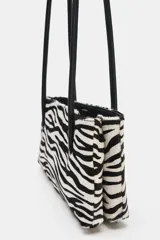 Bolso de hombro de piel con textura, diseño de estampado animal tipo cebra en blanco y negro, doble asa fina de hombro en color negro y cierre con botón imantado.