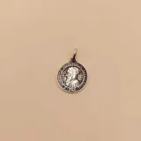 Medalla religiosa de San Benito circular, fabricada en plata 925 con acabado envejecido que resalta los detalles del relieve.