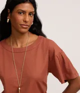 Blusa color ladrillo de tejido piquet con viscosa certificada, modelo t-shirt box, escote redondo y mangas cortas con pliegues.