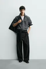 Camisa de corte relajado confeccionada en voile de algodón, con estampado de cuadros. Presenta cuello solapa, manga larga con puños abotonados, bolsillo de parche en el pecho y cierre frontal de botones.