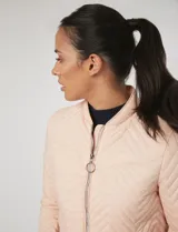 Campera bomber capitoneada color rosa pastel, con diseño acolchado en chevrón, cuello mao, cierre frontal y bolsillos laterales con tiradores metálicos circulares.