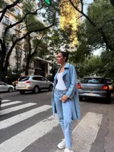 Trench de jean largo con diseño relajado, cuello solapa, cierre frontal con botones y charreteras en los hombros.