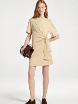 Vestido corto de cuello redondo y manga corta, con detalle de nudo lateral y caída fluida.