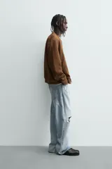 Cazadora bomber negra de corte regular fit, confeccionada en tejido efecto ante. Cuenta con cuello, puños y bajo en rib elástico, manga larga, bolsillos de vivo en la cadera y un bolsillo interior. Cierre frontal con cremallera.