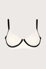 Top de bikini estilo corsetero color blanco con ribetes negros en contraste. Cuenta con varillas inferiores para mayor estructura, breteles ajustables y cierre en la espalda.