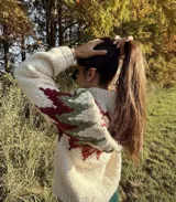 Sweater de lana color crema con cuello alto y diseño geométrico en tonos verde y bordó. Tejido a mano.