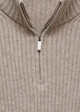 Jersey de punto acanalado color beige, con cuello alto y cierre frontal parcial. Presenta un diseño entallado de largo medio y mangas largas con terminación acampanada.