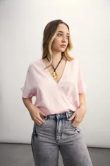 Blusa negra de diseño cruzado con escote en V y mangas cortas, de calce holgado.