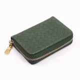 Billetera verde con diseño tejido y cierre dorado.