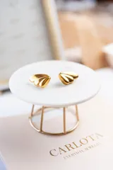 Aros dorados con forma de abanico, fabricados en acero quirúrgico con baño de oro de 18k.