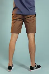 Bermuda de gabardina color tostado, de corte recto y largo por encima de la rodilla, con cierre y botón frontal.