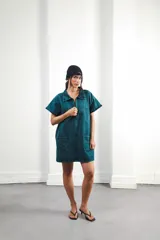 Vestido corto marrón con efecto desgastado, cuello camisero, cierre frontal con cremallera metálica, mangas cortas, dos bolsillos frontales y bordados de soles en el canesú delantero y trasero.