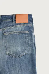 Jeans flare fit de tiro medio, confeccionados en denim de algodón color azul con efecto deslavado. Diseño ajustado en la parte superior y abierto en campana desde la rodilla, con cinco bolsillos y cierre frontal con cremallera y botón.