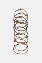 Pack de nueve pulseras elásticas doradas con abalorios y piezas metálicas combinadas de diferentes formas y tamaños.