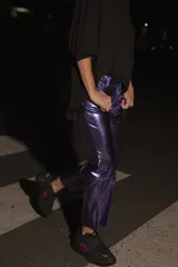 Pantalón de ecocuero color violeta metalizado, con corte capri semi oxford y tiro medio-alto. Presenta cierre frontal con botón metálico y bolsillos traseros.