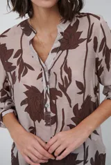 Camisa de manga larga con estampado floral en tonos marrones y negros, cuello mao y cierre frontal parcial con botones.