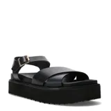 Sandalias Miss Carol modelo Marbela, de color negro con plataforma flatform recta y suela con relieve texturizado. Capellada con tiras anchas cruzadas sobre el empeine y correa trasera con hebilla metálica dorada para ajuste seguro.