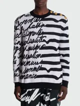 Buzo de punto con rayas horizontales blancas y negras, con texto manuscrito en negro y botones dorados en el hombro.