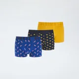 Pack de tres boxers para hombre. Incluye un boxer amarillo liso, un boxer azul marino con estampado de patos amarillos y un boxer azul con estampado de flamencos rosados. Todos tienen cintura elástica con la palabra "ULTIMATE" grabada.
