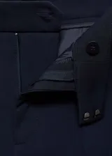 Pantalon de vestir de corte recto y tiro medio, con bolsillos laterales y bolsillos de ribete en la parte posterior. Presenta trabillas para cinturón y cierre frontal.