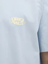 Camiseta celeste de algodón orgánico con cuello redondo y estampado amarillo en la espalda con la palabra 'ORIGINALS' y texto alusivo a la marca.